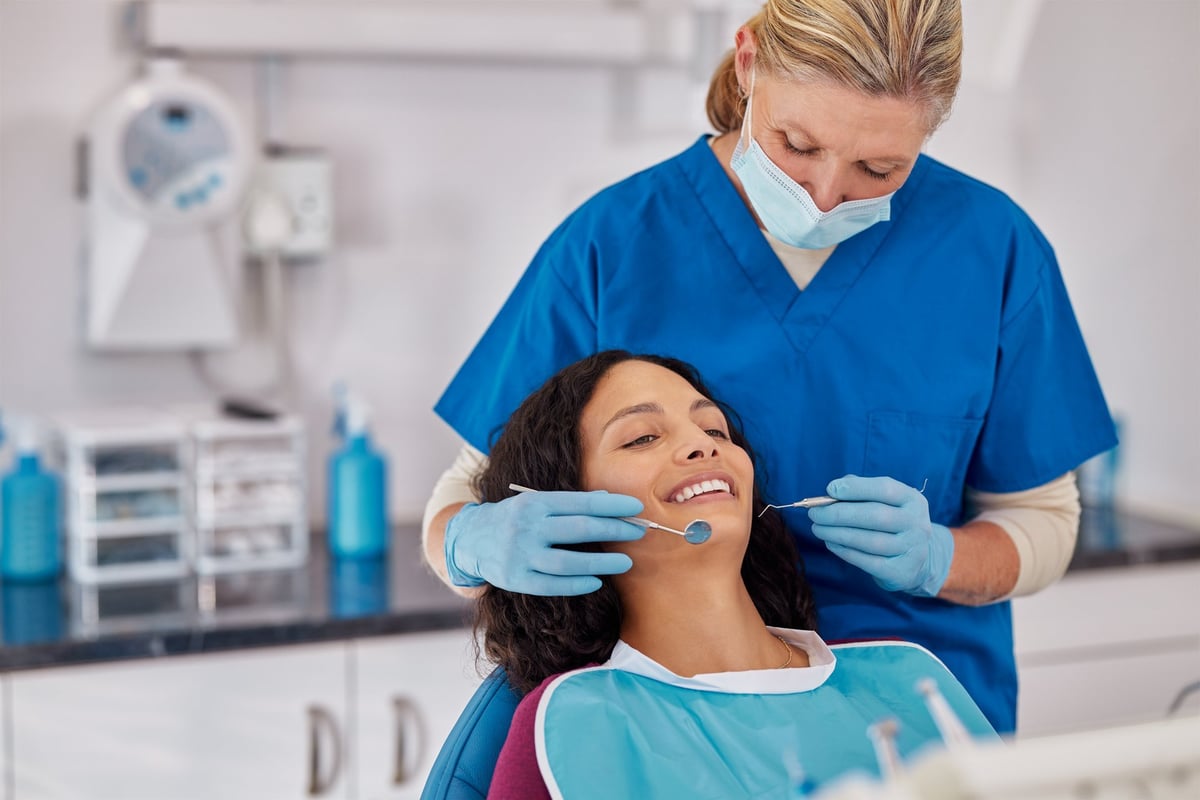 Multiethnic woman smiling while receiving dental care in a modern dental clinic.
